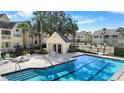 Beautiful community pool area featuring a pool house, lounge chairs, and well-manicured landscaping at 1033 S Hiawassee Rd # 2628, Orlando, FL 32835