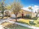 Bright single-Gathering home with a red door and beautifully landscaped front yard at 1049 Winding Water Way, Clermont, FL 34714