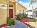 Attractive single-Gathering home with a red front door and manicured landscaping at 1049 Winding Water Way, Clermont, FL 34714