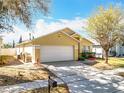 Single-Gathering home featuring a two-car garage and a well-maintained front yard at 1049 Winding Water Way, Clermont, FL 34714