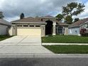 Attractive single-story home featuring a spacious driveway, two-car garage, arched entryway, and beautifully kept lawn at 10536 Cherry Oak Cir, Orlando, FL 32817