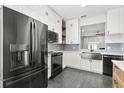 Bright kitchen with stainless steel appliances, white cabinets and blue tile backsplash at 122 Capri Dr, Davenport, FL 33897