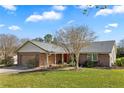 Inviting single-story brick home with a well-manicured lawn, attached garage, and a welcoming front porch area at 12235 Warren Rd, Clermont, FL 34711