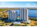 Aerial view of two upscale residential towers with lake views, a pool, and convenient parking at 13427 Blue Heron Beach Dr # 103, Orlando, FL 32821