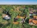 An aerial view of a property featuring lush trees, a fenced yard, and a swimming pool at 145 W Fern Dr, Orange City, FL 32763