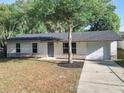 Charming single-story home featuring a well-maintained lawn, gray door, and attached two-car garage at 145 W Fern Dr, Orange City, FL 32763