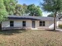 Charming single-story home featuring a well-maintained lawn, gray door, and attached two-car garage at 145 W Fern Dr, Orange City, FL 32763