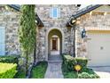 Inviting stone entryway with arched doorway and manicured landscaping at 16736 Broadwater Ave, Winter Garden, FL 34787