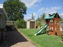 Spacious backyard with a playset, shed, and brick-paved walkway for outdoor enjoyment and storage at 2014 Corner Meadow Cir, Orlando, FL 32820