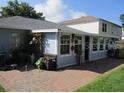 Enclosed sunroom with lots of windows offering natural light with access to a brick patio in backyard at 2014 Corner Meadow Cir, Orlando, FL 32820