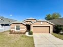 Charming single-story home with a well-maintained lawn and a two-car garage at 2073 Newtown Rd, Groveland, FL 34736