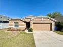 Charming single-story home with a well-maintained lawn and a two-car garage at 2073 Newtown Rd, Groveland, FL 34736