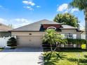 Lovely single-story home featuring manicured landscaping, a two-car garage, and a well-maintained lawn at 2258 Crystal Falls Way, Orlando, FL 32824