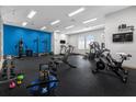 Bright gym with a variety of exercise equipment, weights, and treadmills set against a vibrant blue accent wall at 2306 Lancashire St, Davenport, FL 33896