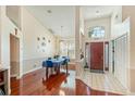 Elegant dining room showcasing hardwood floors, a stylish light fixture, and a view into the tiled foyer at 2821 Lone Feather Dr, Orlando, FL 32837