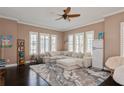 Bright living room featuring dark hardwood floors, neutral walls, plush sectional, and vintage style refrigerator at 316 Trieste Loop, Lake Mary, FL 32746