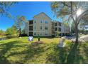 Three story condo building with attached garages and a scenic view of pond at 413 Summit Ridge Pl # 115, Longwood, FL 32779