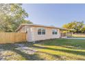 A charming home featuring a wooden fence, a carport, and a well-maintained lawn at 4320 Meadowbrook Ave, Orlando, FL 32808