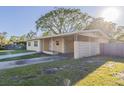 Inviting single-story home showcasing a convenient carport and well-kept landscaping at 4320 Meadowbrook Ave, Orlando, FL 32808