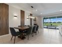 Dining area with a wooden table and gray upholstered chairs, complemented by modern lighting and a sliding glass door at 4321 Lana Avenue, Davenport, FL 33897