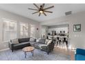 Open-concept living room with oversized couch, ceiling fan, and seamless transition to the modern kitchen at 4474 Virginia Dr, Orlando, FL 32814