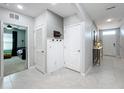 Clean, bright hallway featuring a coat rack, linen closet, and access to multiple rooms with tile flooring at 460 Lily Ln, Davenport, FL 33837