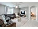 Comfortable living room with a large sectional sofa, modern ceiling fan, and mounted TV at 460 Lily Ln, Davenport, FL 33837