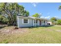 A single-story home has a gray exterior, a red front door, and a well-manicured lawn and landscaping at 5210 Grandview Dr, Orlando, FL 32808