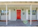 Inviting front porch featuring a bright red door, decorative lighting, and classic shuttered windows at 5210 Grandview Dr, Orlando, FL 32808