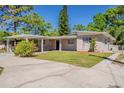 Well-maintained single-story home with a covered parking area and lush landscaping at 5909 Avery St, Orlando, FL 32808