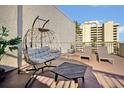 Relaxing rooftop deck with hanging egg chair, lounge chairs, small fire pit, and views of nearby building at 6165 Carrier Dr # 3512, Orlando, FL 32819