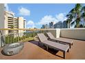 Rooftop deck featuring two lounge chairs, a fire pit, and views of the cityscape under a partly cloudy blue sky at 6165 Carrier Dr # 3512, Orlando, FL 32819