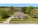 Aerial view of a peach colored single Gathering home with mature landscaping, lake view, and large lot at 6651 Sylvan Woods Dr, Sanford, FL 32771