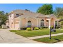 Beautiful peach colored single-Gathering home featuring a well-kept lawn and an attached two car garage at 6651 Sylvan Woods Dr, Sanford, FL 32771