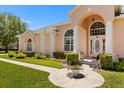 Close up of front of property showcasing the arched windows, manicured shrubs, and stone walkway at 6651 Sylvan Woods Dr, Sanford, FL 32771