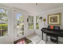 Bright entryway featuring a tiled floor, glass-paneled door, and a piano, with natural light streaming through the windows at 801 Silver Dr, Orlando, FL 32804