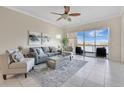 Bright living room with neutral tones, tile flooring, and sliding glass doors to the balcony at 8743 The Esplanade # 11, Orlando, FL 32836