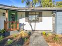 Inviting front entrance with a green door, brick walkway, and fresh landscaping at 905 W 11Th Ave, Mount Dora, FL 32757