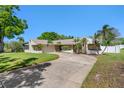 Charming single-story home with a manicured lawn, stone accents, and a wide driveway at 9109 Galleon Dr, Orlando, FL 32819