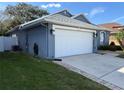 Side view of a cozy home with a two-car garage, vibrant green grass and freshly painted exterior at 938 Cherry Valley Way, Orlando, FL 32828