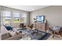 Bright living room with large windows, stylish furniture, and a decorative rug at 124 Adventure Ave, Davenport, FL 33837