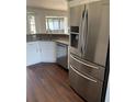 Stainless steel refrigerator and kitchen sink complimented by white cabinetry and gray countertops at 12546 Britwell Ct, Orlando, FL 32837