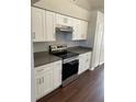 Modern kitchen with white cabinetry, stainless steel appliances and gray countertops at 12546 Britwell Ct, Orlando, FL 32837