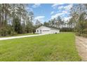 Expansive front yard view of a one-story home with an attached two-car garage and a pristine driveway at 13457 Sw 53Rd St, Ocala, FL 34481