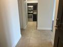 View from the entryway into the kitchen, featuring tiled floors and modern appliances at 13929 Fairway Island Dr # 822, Orlando, FL 32837