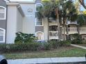 Exterior of the condo featuring balconies, manicured bushes and shrubs, and a well maintained lawn at 13929 Fairway Island Dr # 822, Orlando, FL 32837