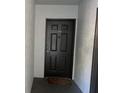 A simple black front door with a knocker and unit number 822. The door has rectangular indents for design at 13929 Fairway Island Dr # 822, Orlando, FL 32837