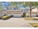 Inviting townhome showcasing a two-car garage, brick paver driveway, and well-maintained landscaping at 1613 Priory Cir, Winter Garden, FL 34787