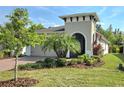 Landscaped front yard of a single-story home with brick paver driveway and tropical plants at 225 Vestrella Dr, Kissimmee, FL 34759