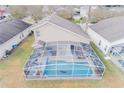 Aerial view of the screened-in backyard showcasing the in-ground pool, lounge chairs, and outdoor dining area at 252 Julliard Blvd, Davenport, FL 33897